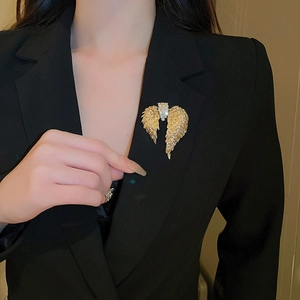 Detailed view of angel wing brooch with crystals on a black suit lapel