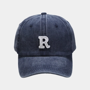 Close-up of embroidered white R letter and washed cotton texture on baseball cap