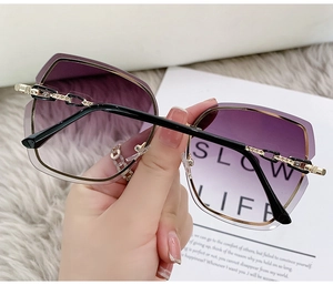 Detail of purple gradient rimless lens and golden chain temples of fashion sunglasses