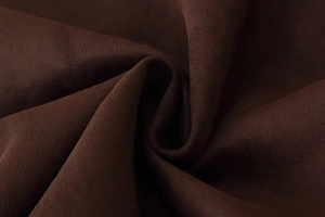 Macro shot of dark coffee suede fabric showing soft texture and fine velvet grain detail