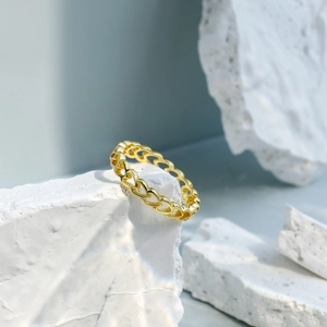 Minimalist gold heart chain ring displayed on white natural stone for women