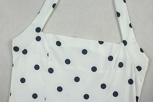 Close-up of halter neckline and square collar on a black and white polka dot mini dress