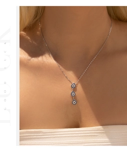 Model wearing a S925 sterling silver necklace with blue evil eye teardrop pendants