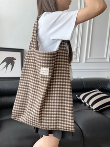 Retro brown plaid wool tote bag with long straps shown in a modern living room setting