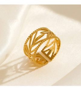Macro view of gold leaf shaped adjustable ring on a soft silk background texture