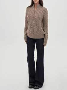 Detail of dark blue slim fit bootcut jeans paired with a brown knit sweater