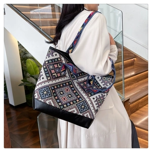 Ethnic canvas tote bag with geometric patterns worn by a model on a shoulder