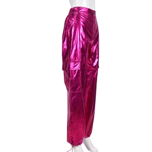 Detail of rose pink metallic cargo pants showing side pockets and glossy fabric texture
