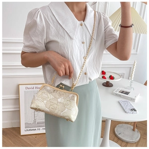 Detailed view of white jacquard Cheongsam handbag with gold frame and chain strap