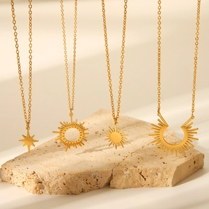 Detail of 18K gold stainless steel necklaces with sun and star pendants on stone base