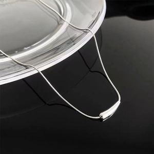 Collana minimalista a catena snake argento con pendente a barra curva su base nera