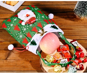 Detail der Weihnachts-Kordelzugtasche mit Weihnachtsmann-Stickerei und festlichen Süßigkeiten