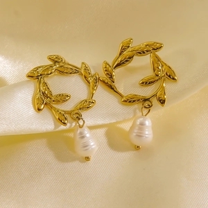 Elegant 14K gold leaf earrings with teardrop pearl pendants on silk background