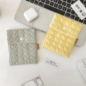 Detailed view of quilted cotton storage pouch with heart stitching and snap button