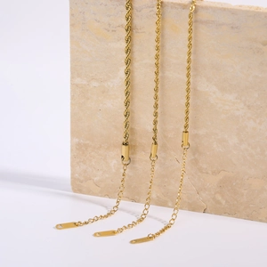 Set of three gold-plated stainless steel rope chains in various widths on stone display