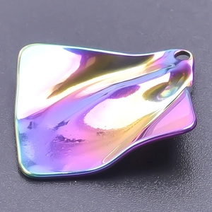 Macro shot of an irregular wave pendant with rainbow plating and smooth metallic texture