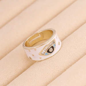 Detail of gold Evil Eye heart ring with colorful zircon inlays on beige velvet base