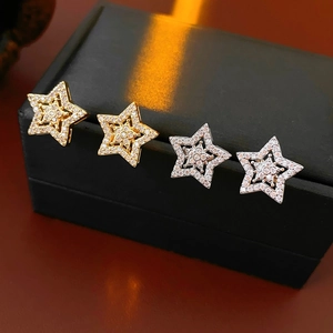 Detail of four star-shaped stud earrings in gold and silver with micro-pave cubic zirconia