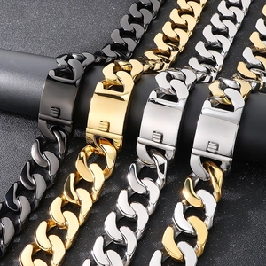 Close-up of thick Cuban chain bracelets in black, gold, silver, and two-tone finishes