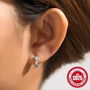 925 Sterling Silver turquoise huggie hoop earrings on model with sparkling cubic zirconia