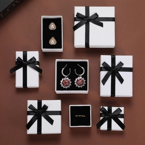 White jewelry gift boxes with black bows and velvet lining for rings and necklaces