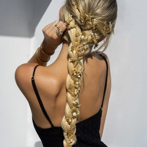 Golden bridal hairpins with pearls and starfish charms on a braided hairstyle