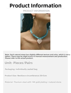 Macro detail of ice blue cat eye bead necklace with pink heart pendant in 18K gold plated steel