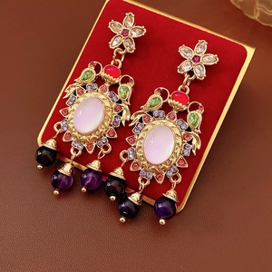 Macro detail of vintage floral earrings with colorful crystals on red velvet jewelry box