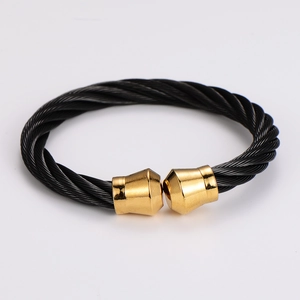 Macro shot of twisted black cable wire bracelet with polished gold-tone metal end caps