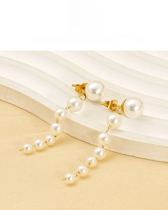 Detail of 18K vacuum plated long pearl tassel earrings on a wavy display stand