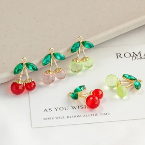 Sparkling crystal cherry pendants in various colors with golden metal rings