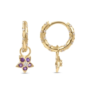 Close-up of gold huggie earrings with purple flower pendants and white zircon stones