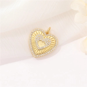 Macro detail of gold micro-pave heart pendant with zircon border on white fabric