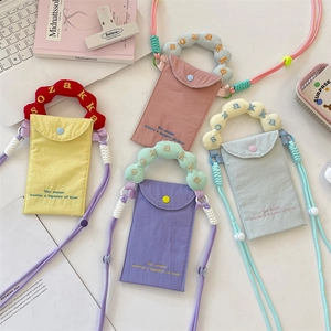 Detail of colorful canvas phone bags with contrast embroidery and adjustable straps