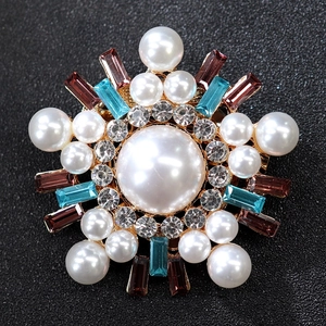Macro shot of luxury starburst brooch featuring blue crystals and white pearls on gold