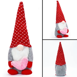 Three-sided view of a plush Valentine gnome holding a pink heart with a red hat