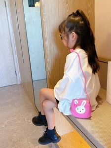 Cute pink bunny shoulder bag for girls with a 3D bow and slim strap on a child model