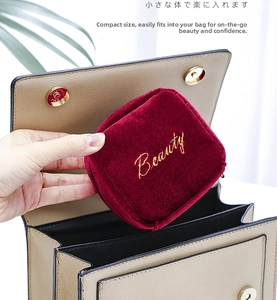 Mini velvet lipstick pouch with golden Beauty embroidery inside a lady handbag