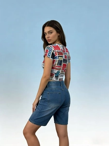 Detail shot of blue denim shorts and colorful vintage geometric print short sleeve t-shirt