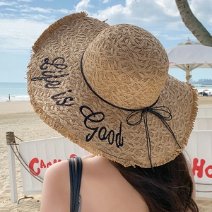 Detail of wide brim straw hat with black Life is Good embroidery and frayed edges