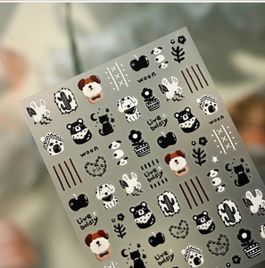 Detail of 3D embossed nail stickers featuring cute black and white hand-drawn cartoon pets
