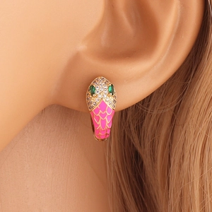 Close-up of gold snake huggie earring with pink enamel, zircons and green stone eyes