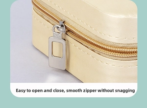 Detail of a smooth champagne gold zipper and leather texture on a portable jewelry box