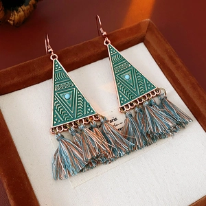 Detail shot of vintage triangle earrings with bronze frame, teal beads and soft silk tassels
