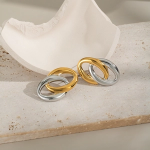 Dettaglio degli anelli intrecciati oro e argento su decoro in pietra e ceramica