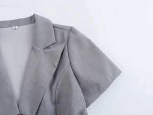 Détail du col à revers gris et de l'épaule rembourrée sur un costume blazer tailleur
