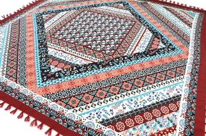 Close-up of bohemian square scarf featuring intricate geometric patterns and red fringe