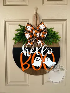 Close-up of wooden door sign featuring white ghost, hello BOO text, and orange bow decoration