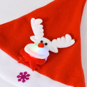 Detail of a glowing reindeer applique with colorful LED lights on a red felt Christmas hat