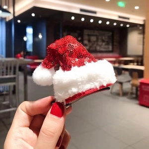 Sparkly red sequin Christmas hat hair clip with white plush trim held in hand